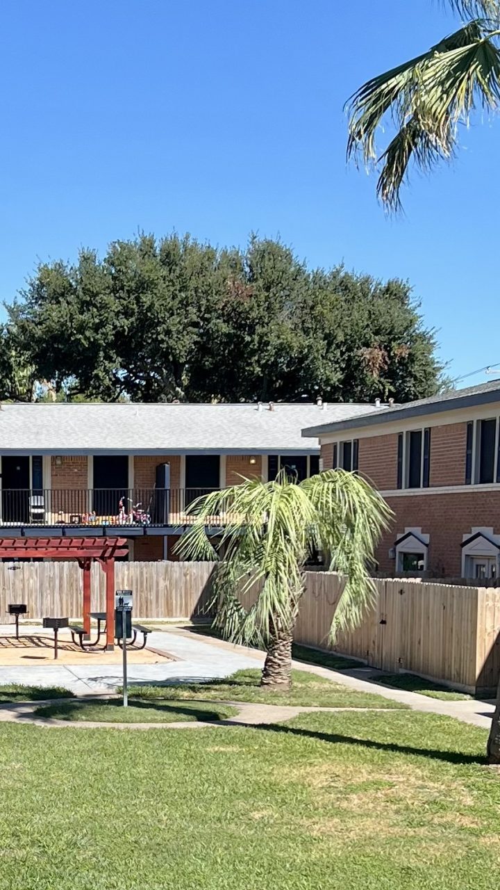 a patio area with a lawn chair and a tennis court